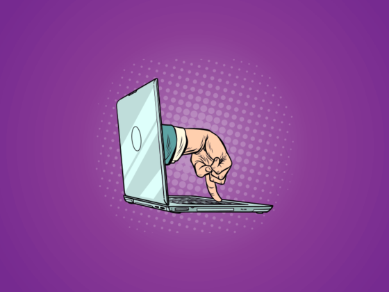 céges blog dilemmáit jelképező kéz, mely egy laptop monitorából előbújva a billentyűzeten matat