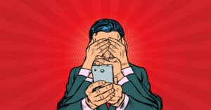 Befogott szemű és szájú ember tart egy telefont